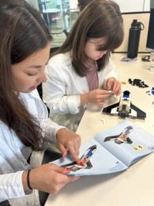 Two young women building the LEGO Mars Research Shuttle.