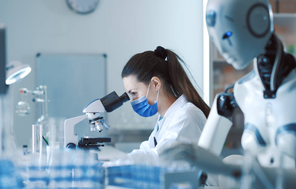 Scientist and AI robot working together in the lab: the woman is looking at the samples under the microscope