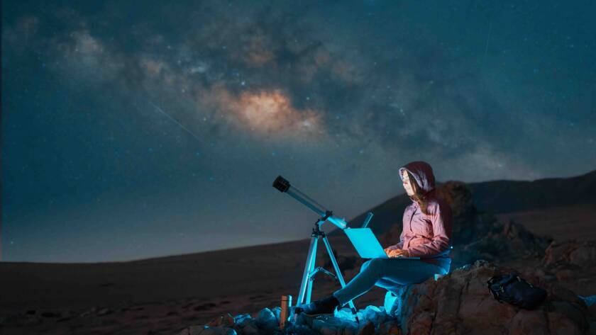 young woman looking at telescope